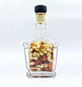 Glass canister made from repurposed Jack Daniel's bottle, filled with dry fruits.