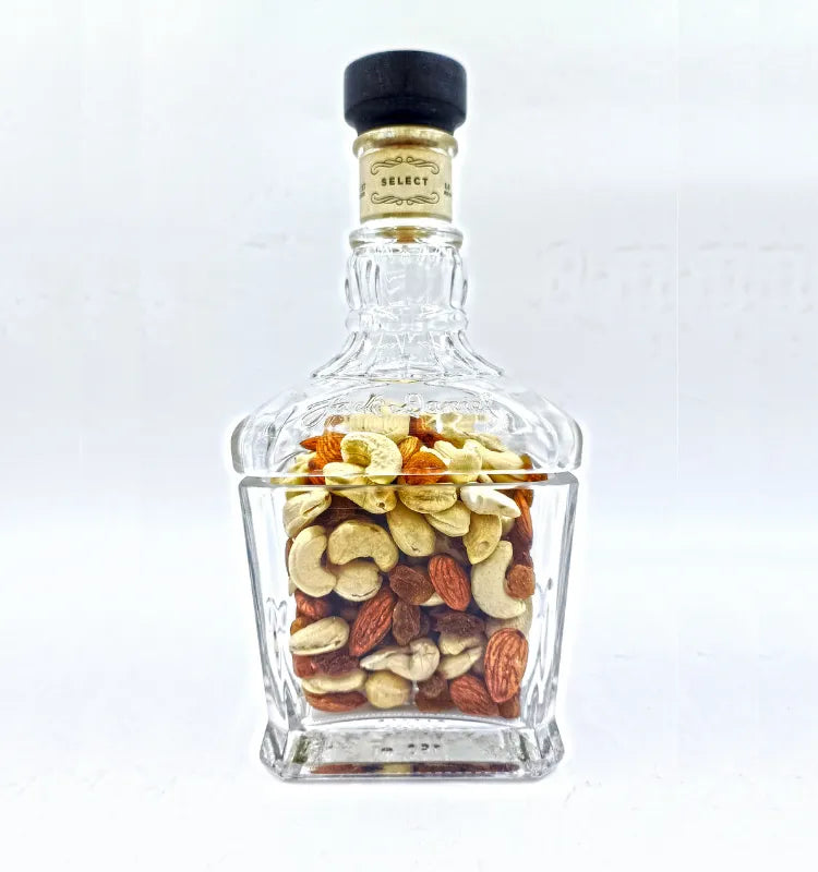 Glass canister made from repurposed Jack Daniel's bottle, filled with dry fruits."