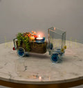 Handcrafted Golden Bloom Truck Planter by Krystal Kraft, designed by Raees Ahmed Merchant using a repurposed Johnnie Walker Gold Label bottle – features a truck-shaped design with a planter bed and candle holder for stylish eco-friendly décor.