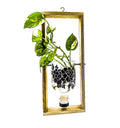 Artistic upcycled gin bottle planter with floral design on wall-mounted frame