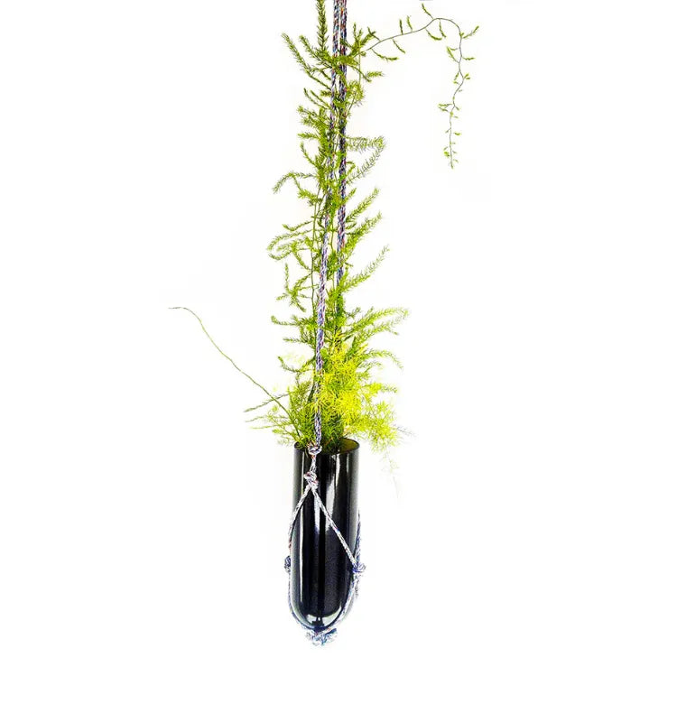 Artistic recycled glass bottle planter with hand-knotted hanger, eco-conscious decoration for home and garden spaces.