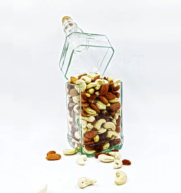 Upcycled Jack Daniel's glass bottle canister filled with almonds, cashews, and raisins. Unique dry fruit storage and rustic home decor.