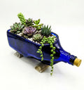 Side view of handcrafted antiquity blue upcycled glass bottle planter