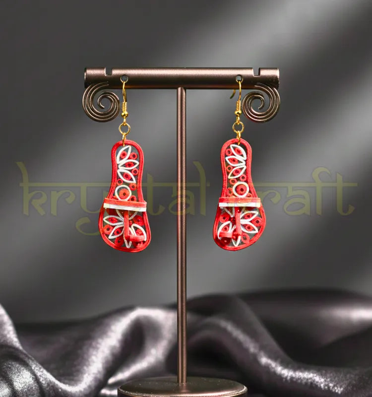 Close-up of handcrafted red and white Kolhapuri style paper quilling earrings by Krystal Kraft, lightweight eco-friendly statement jewelry on a neutral background.