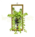 An elegant green wall planter crafted from a recycled gin bottle and framed for vertical display — ideal for eco-conscious home decor, balcony gardening, or modern rustic interiors.