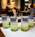 Eco-friendly tumblers handcrafted from recycled Absolut vodka bottles by Krystal Kraft, displayed as a sustainable glassware set of four.