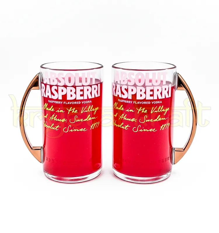 Pair of upcycled Absolut Raspberry bottle mugs with smooth polished finish and metal handles, ideal for coffee, tea, or cocktails in a sustainable, stylish way.”