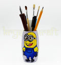 Eco-friendly handmade bottle art showcasing a cute Bob Minion on a pink base, painted with blue and yellow acrylics and sealed with transparent Liquitex.