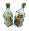 Artistic glass bottle canister storing wrapped candies and dry fruits for elegant home styling.
