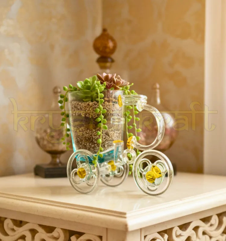 Tezon Tricycle Planter handcrafted by artist Raees Ahmed Merchant from upcycled waste glass bottles — featuring clear glass, golden accent hubs, and a minimalist cup planter, perfect for eco-friendly home or office décor.