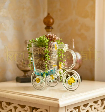 Tezon Tricycle Planter handcrafted by artist Raees Ahmed Merchant from upcycled waste glass bottles — featuring clear glass, golden accent hubs, and a minimalist cup planter, perfect for eco-friendly home or office décor.
