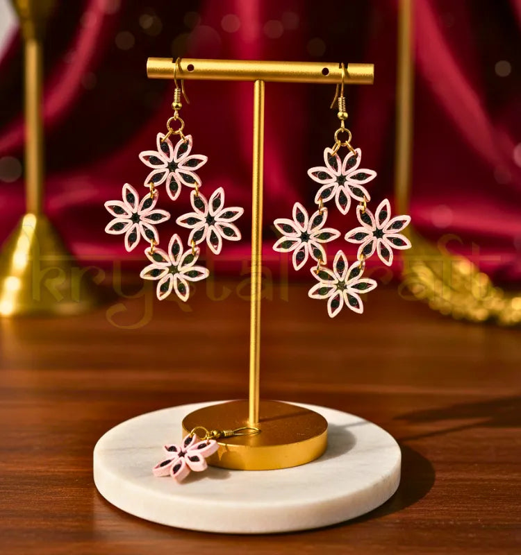 Close-up of maroon floral paper quilling earrings with cream and purple petals, handmade by Krystal Kraft, hanging on ear-wire hooks.