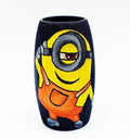 Recycled Amul mini bottle hand-painted with a Cool Minion on a black base using orange and yellow tones — a fun, sustainable table accent by Krystal Kraft.