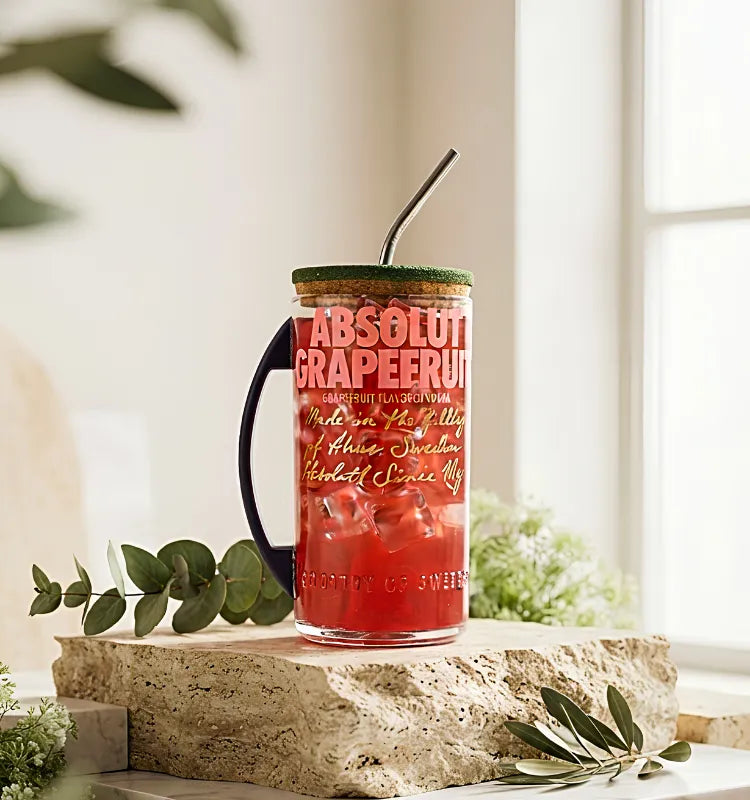 Upcycled Absolut Grapefruit vodka bottle mug with metal handle and sipper lid on neutral background